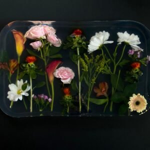 From above of composition of fresh blooming flowers in transparent epoxy resin placed on black surface